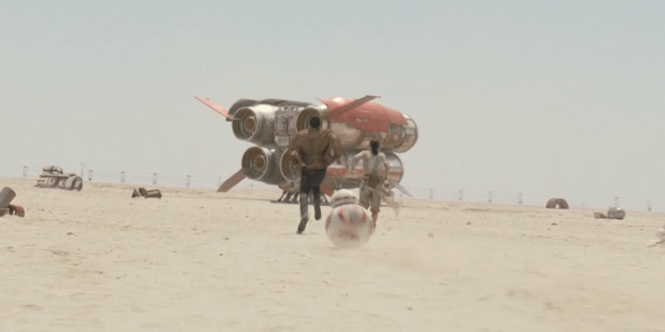 Finn and Rey running toward a quadjumper space ship in The Force Awakens