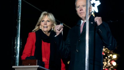Jill and Joe Biden look intenseley in front of them with a large Christmas tree in the background.