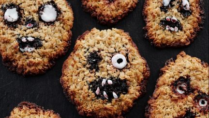 Cookies with scary faces are laid out on a black background.