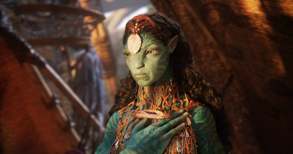 Ronal, a Na'vi with a large shell on her forehead, puts her hand on her chest in Avatar: The Way of Water.
