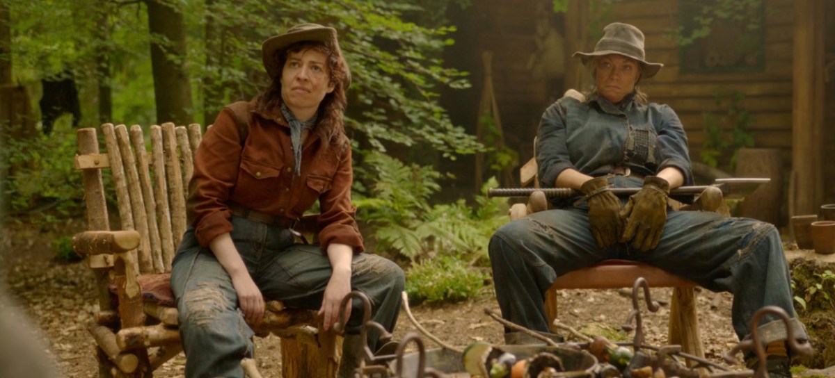 Hubert and Anne sit in wooden chairs in the woods in Willow.