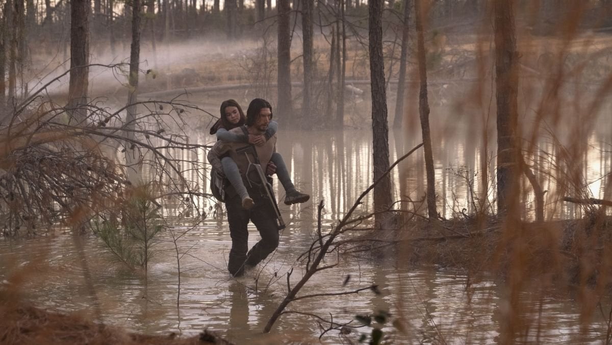 Adam Driver as Mills carries Ariana Greenblatt as Koa through a swamp in '65'