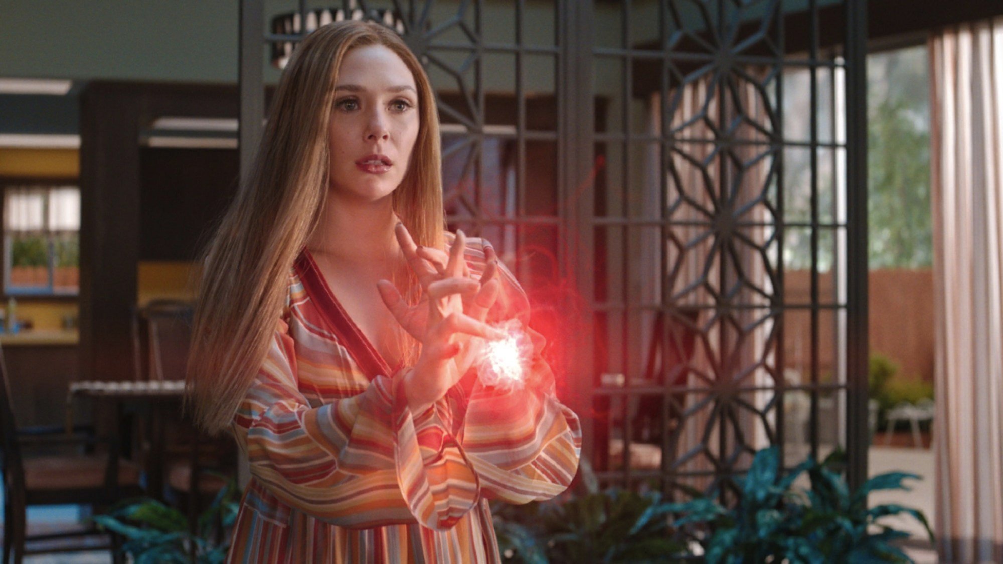 Wanda Maximoff (Elizabeth Olsen) harnesses her power, which looks like a glowing red orb in her hands, in 'WandaVision'