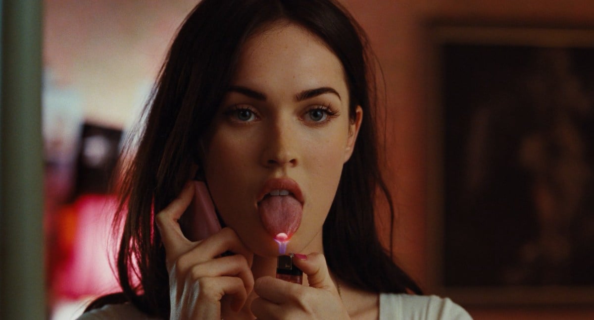 Jennifer (Megan Fox) holds a lighter to her tongue as she talks on the phone in 'Jennifer's Body' 