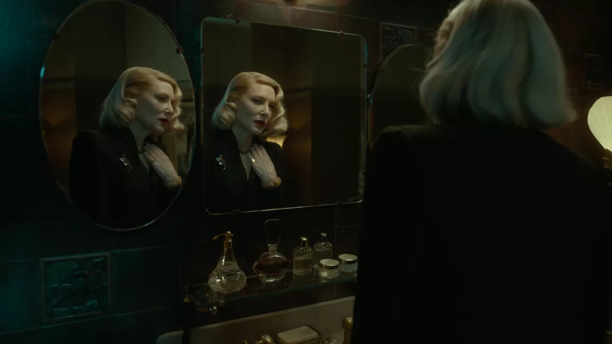 In a still from 'Nightmare Alley,' a woman (Cate Blanchet) looks into a wall of mirrors and is reflected on two of their surfaces