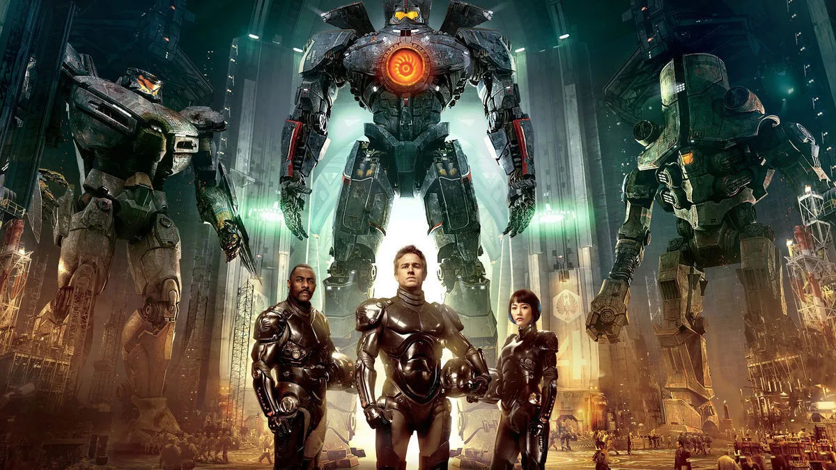 Three pilots standing in front of three giant mech robots in 'Pacific Rim'