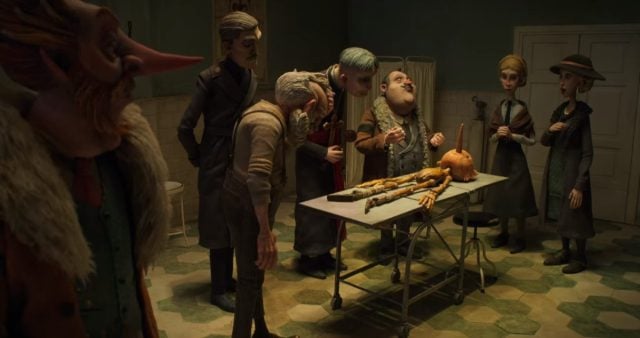 People inspecting Pinocchio's body. Image: Netflix.