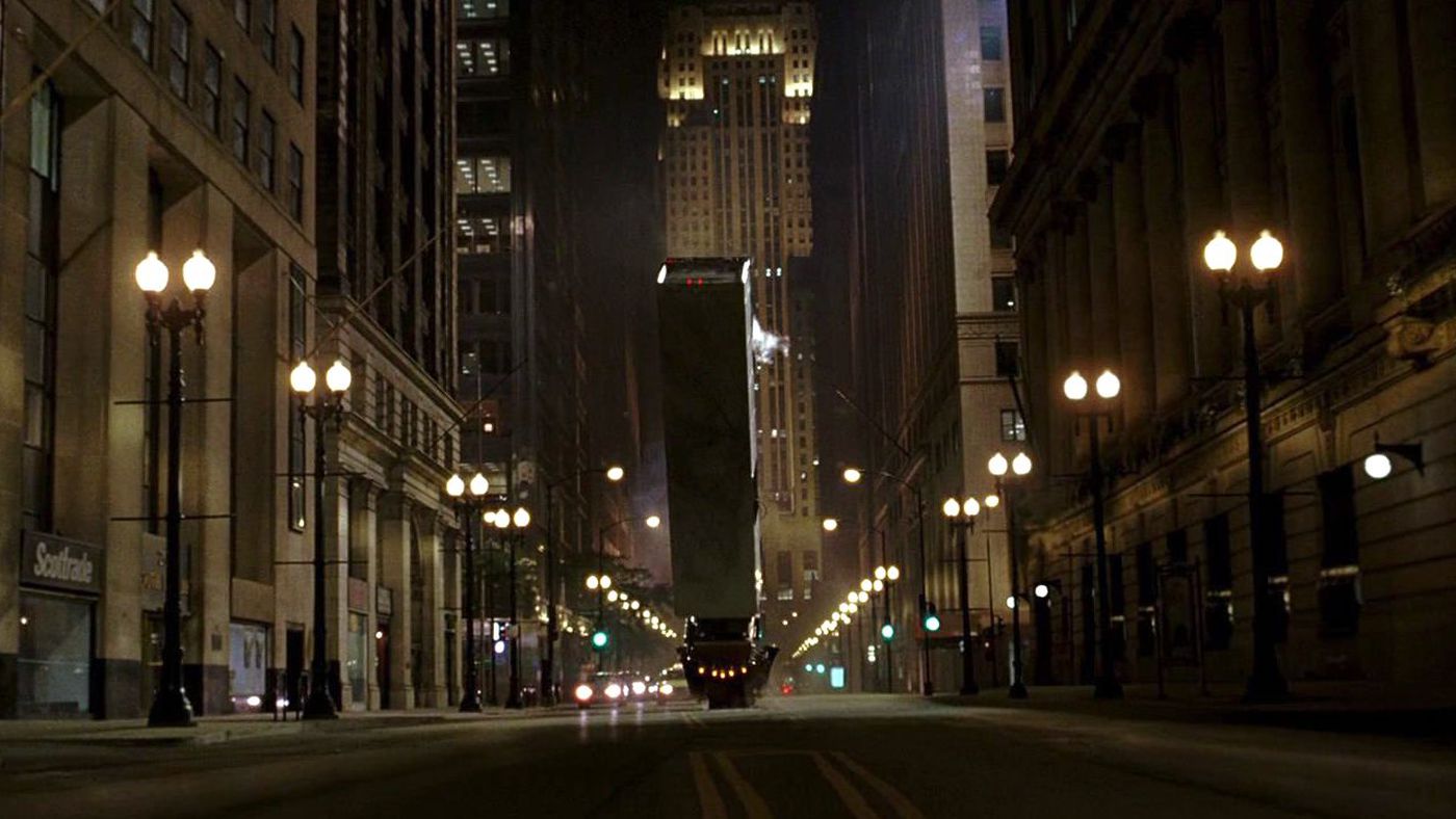 A semi-truck flips over in the middle of a street at night in a still from 'The Dark Knight'