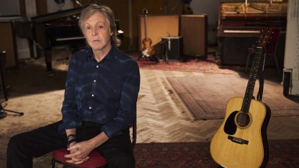 Paul McCartney sitting with a guitar in 'If These Walls Could Sing'