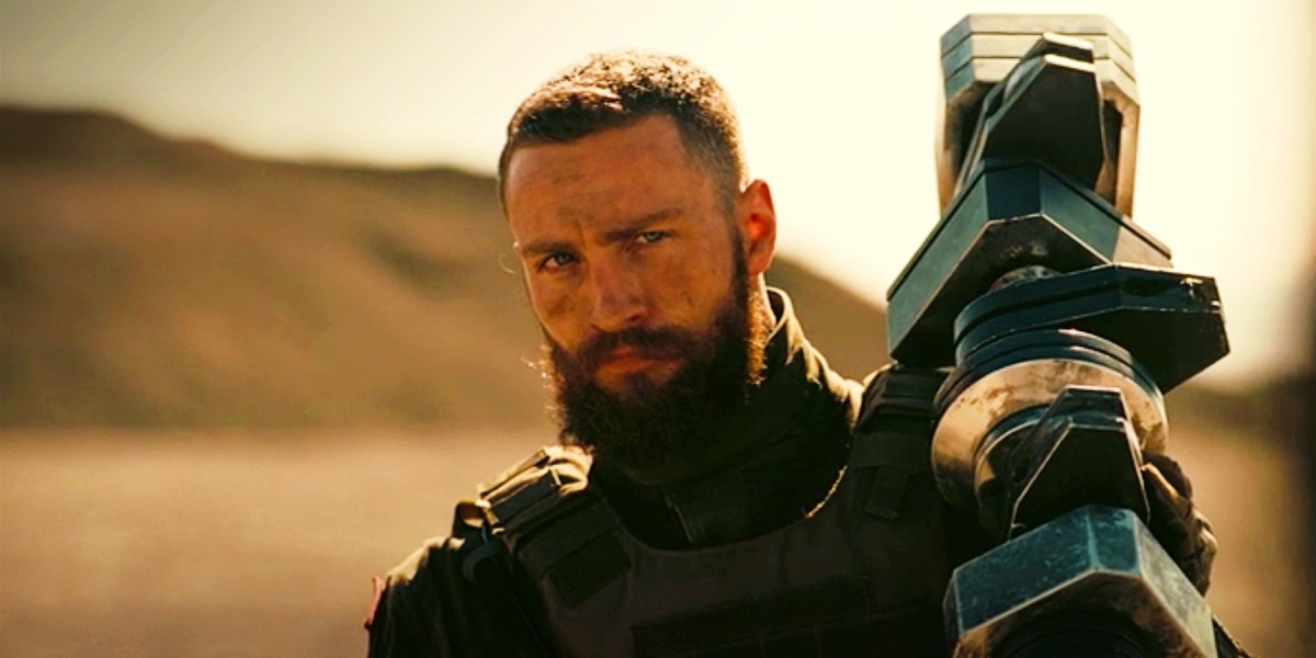 Aaron Taylor-Johnson as Ives holding a gun in Tenet