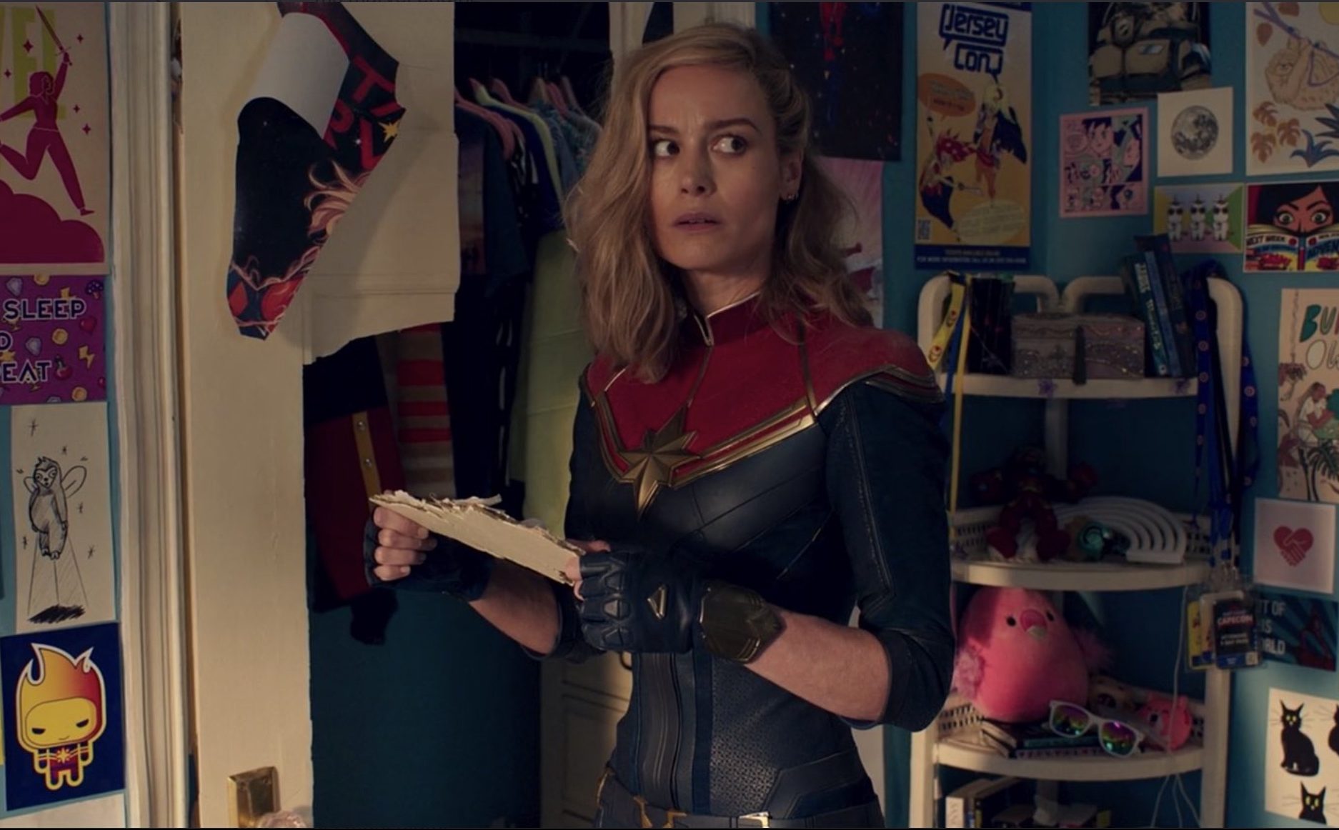 Brie Larson's Captain Marvel stands in a teen girl's bedroom, looking confused in a post-credits scene from the 'Ms. Marvel' finale
