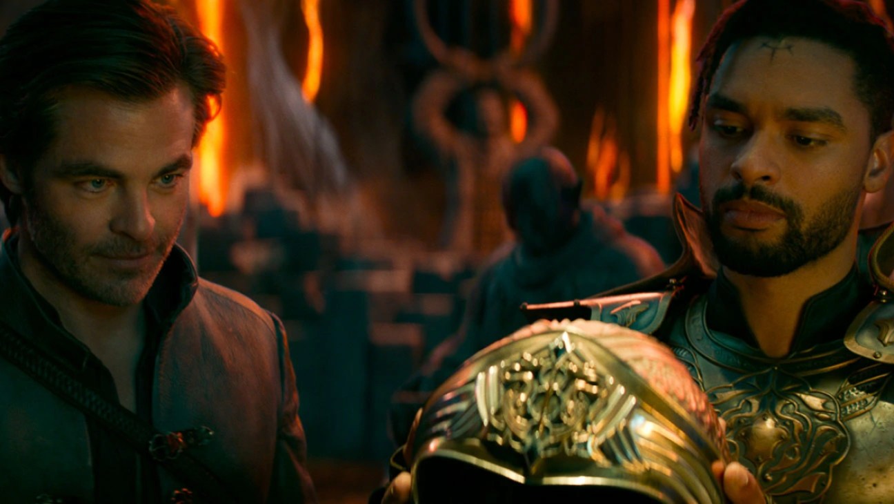 Edgin (Chris Pine) and Xenk (Regé-Jean Page) look upon a golden helmet in a scene from 'Dungeons and Dragons: Honor Among Thieves'