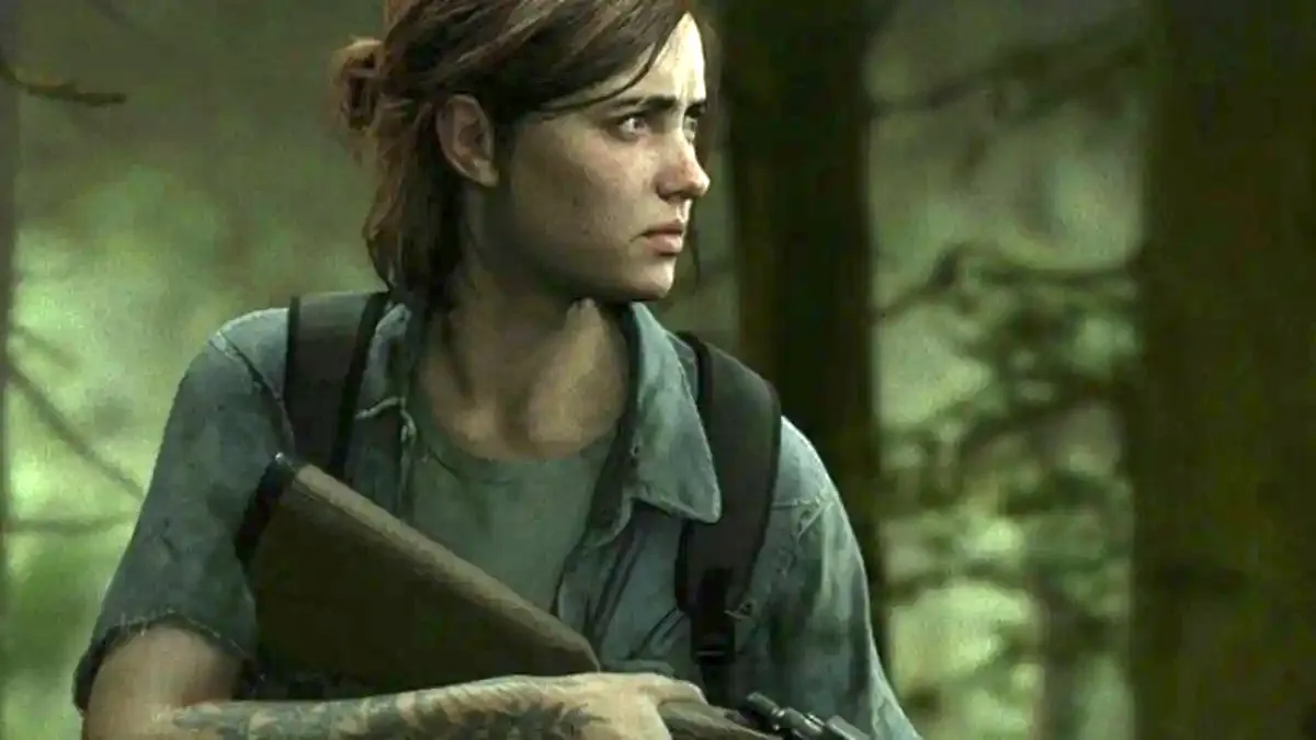 Ellie in The Last of Us, standing in the woods holding a gun, with an unhappy look on her face.