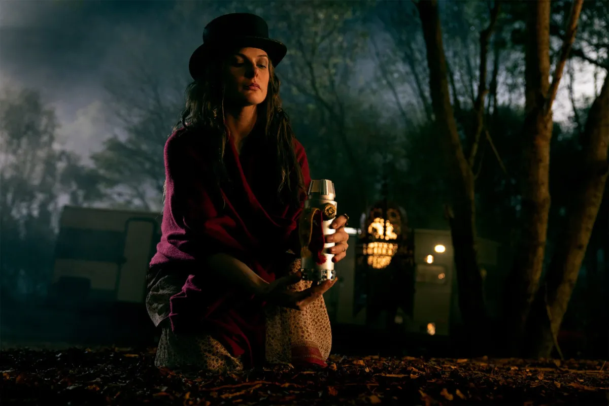 Rose the Hat (Rebecca Ferguson) kneels over a candle in a still from 'Doctor Sleep'