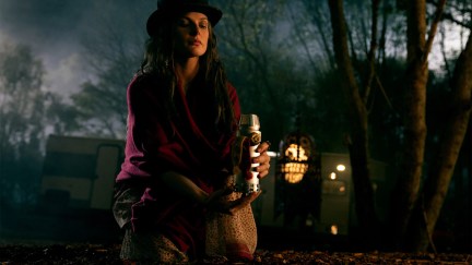 Rose the Hat (Rebecca Ferguson) kneels over a candle in a still from 'Doctor Sleep'