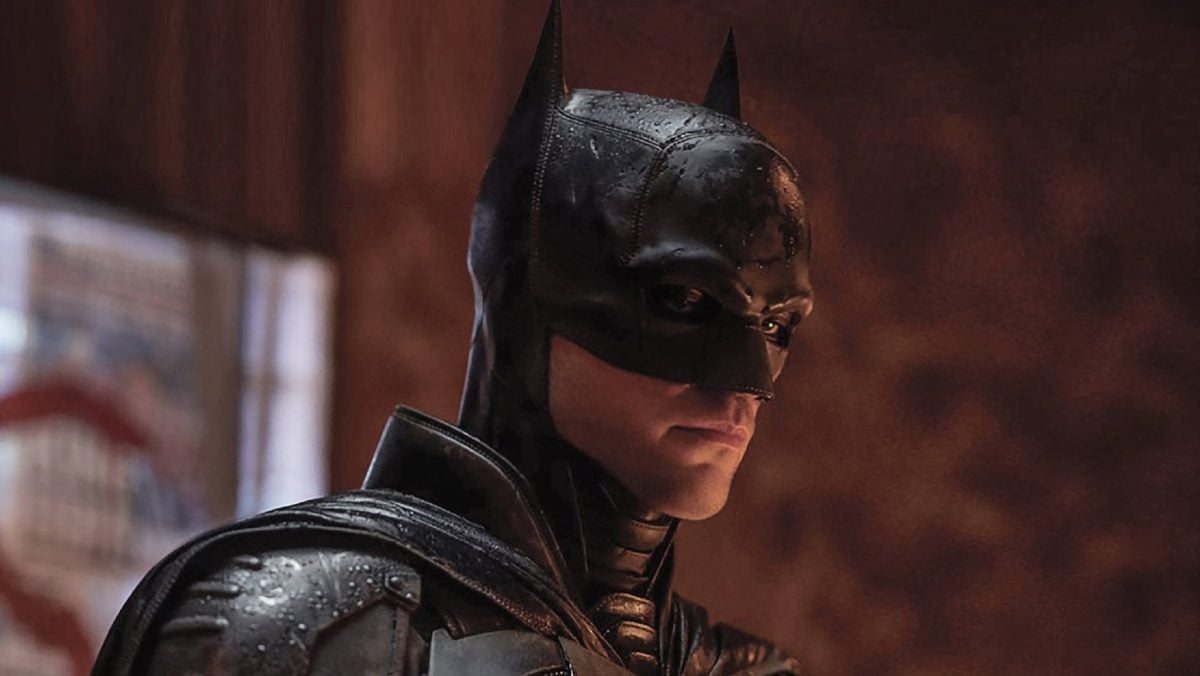 Robert Pattinson as Batman posing and looking down in 'The Batman'