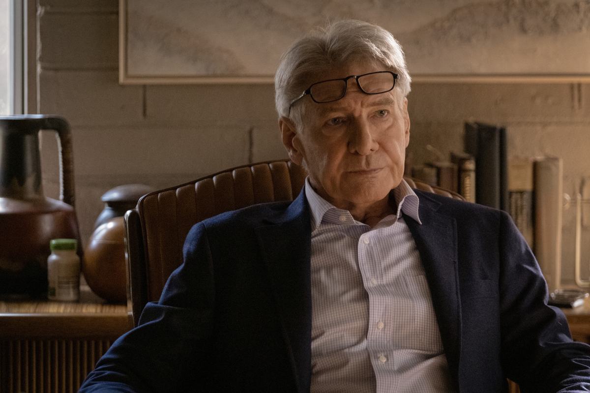 Harrison Ford sitting with glasses on his head in shrinking
