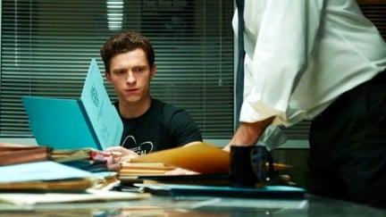 Tom Holland as Peter Parker in Spider-Man: No Way Home. He is reading a folder and looking confused