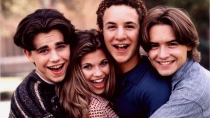 The cast of Boy Meets World poses, grinning at the camera.