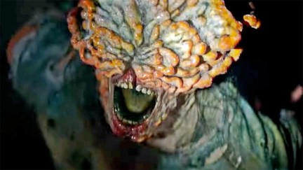 Closeup of a clicker from The Last of Us. The person's mouth is visible under a plume of yellow and blue mushrooms.