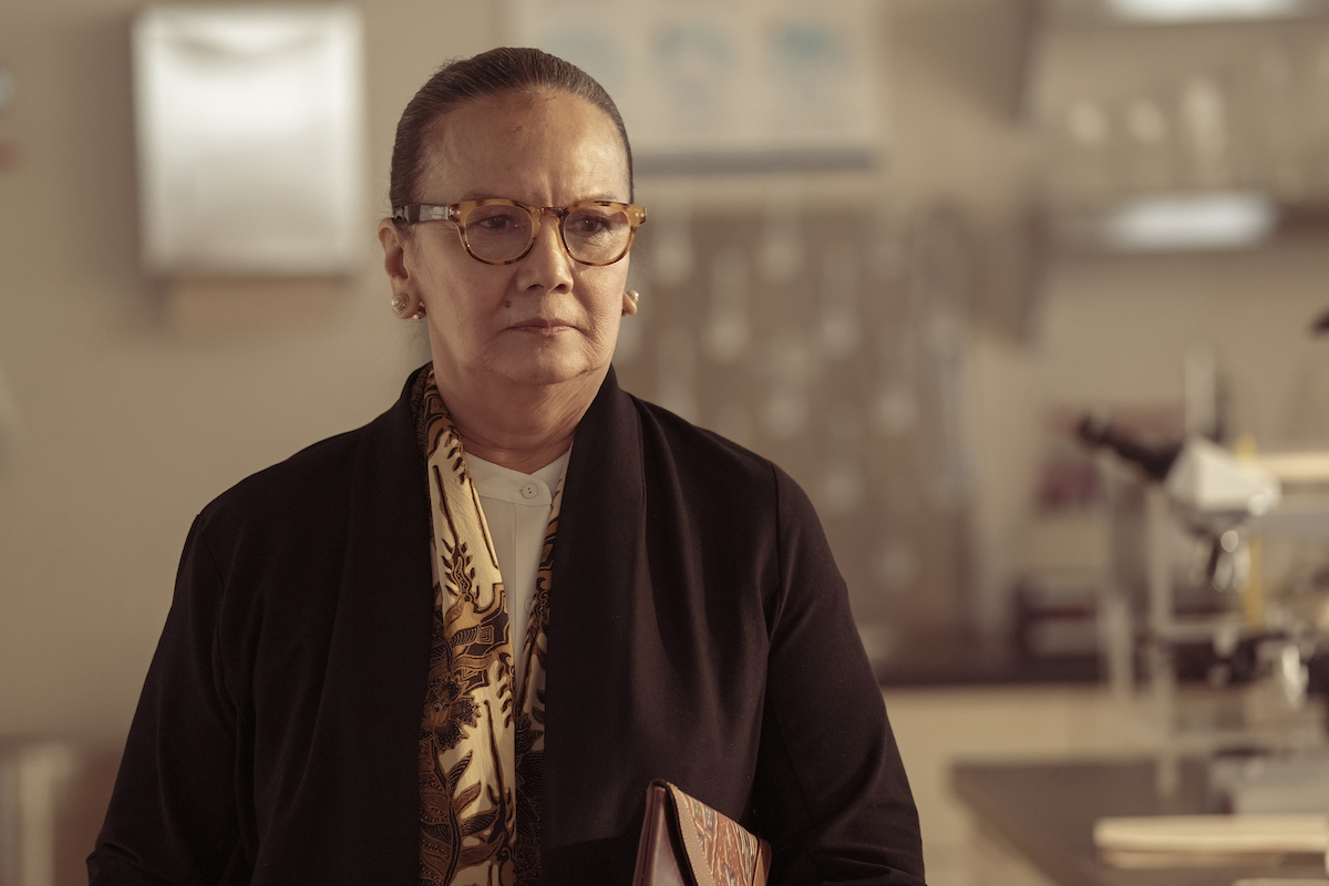 Ibu Ratna (Christine Hakim) frowns in a lab in The Last of Us.