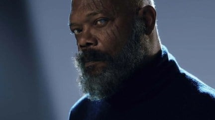 Nick Fury looks at the camera, not wearing an eyepatch. He has scars around his unseeing eye, which is white.