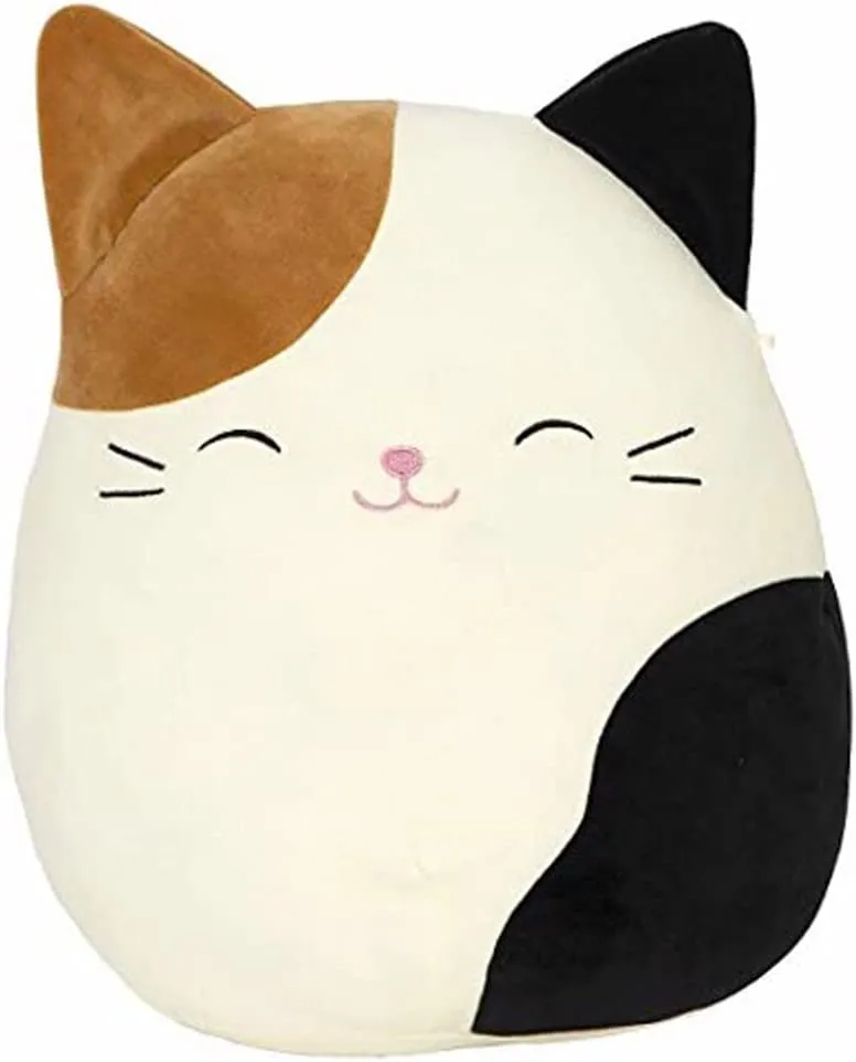 A calico cat Squishmallow with happy closed eyes