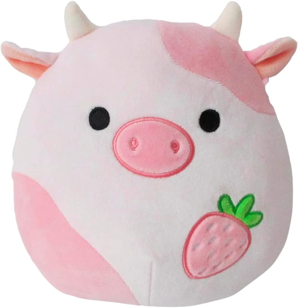 A pink cow squishmallow with a strawberry on her tummy