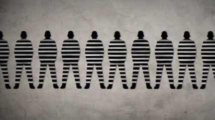 The 13th still showing a row of men in striped prison jumpsuits.