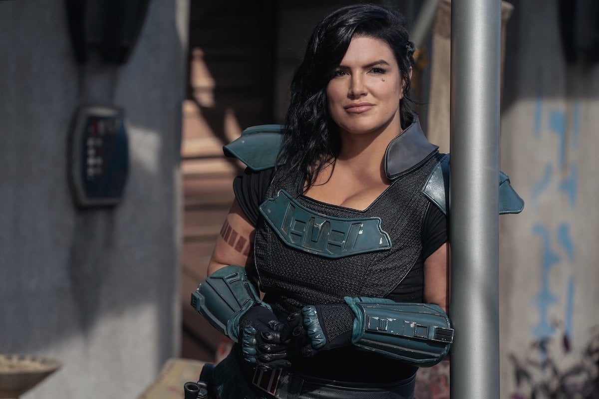 Gina Carano as Cara Dune in The Mandalorian, leaning against an architectural column, looking pensively into the distance
