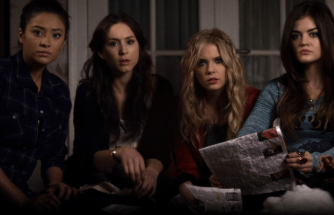 Emily, Spencer, Hanna, and Aria sit in a circle on a bed