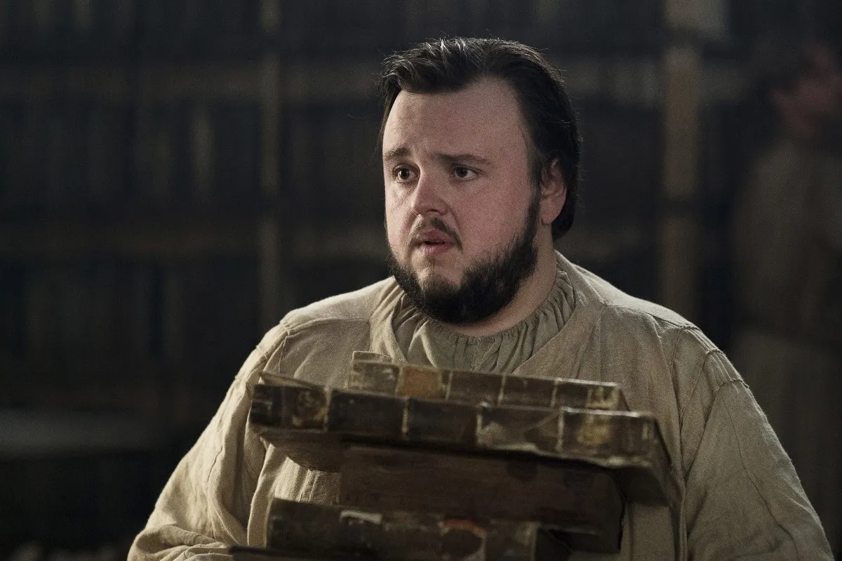 Samwell Tarly holds a stack of books in 'Game of Thrones'