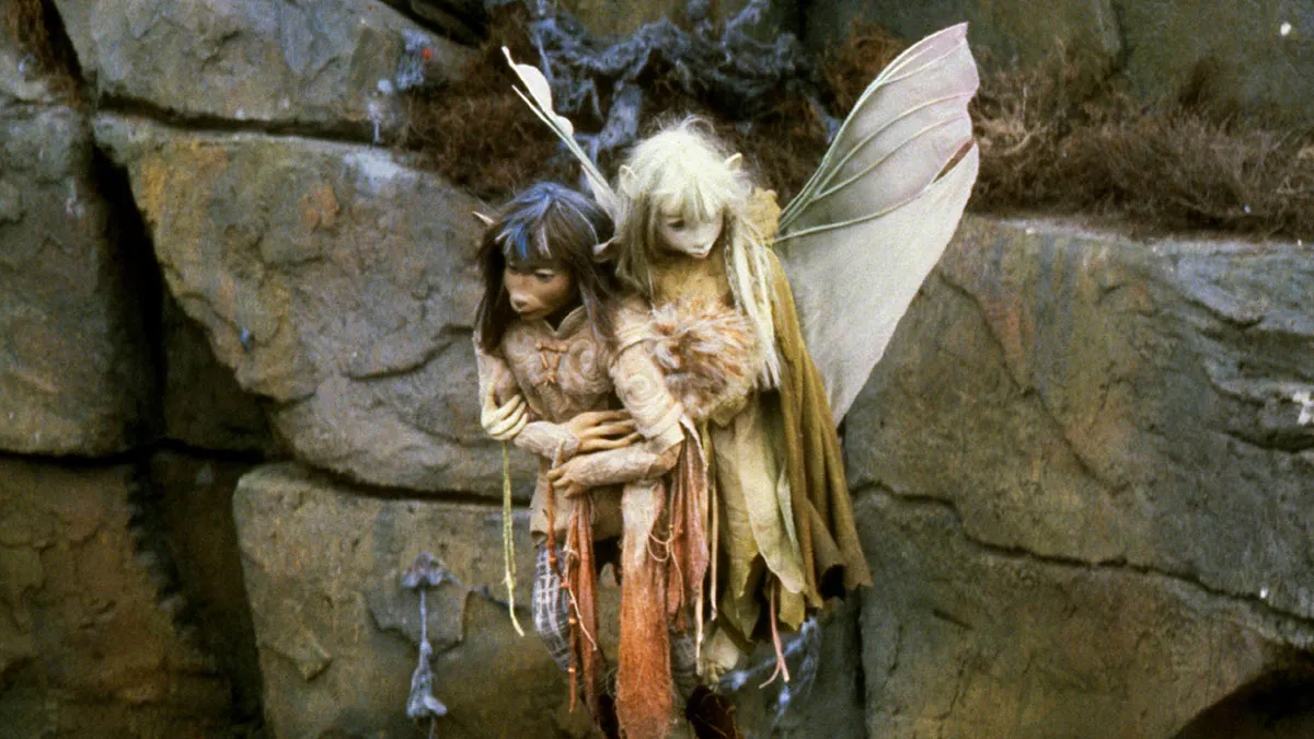 A still from the film The Dark Crystal depicting the Gelflings Jen and Kira flying up the side of a rock face