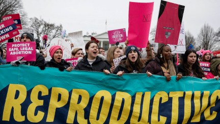 A group of abortion rights protesters carry a banner reading 
