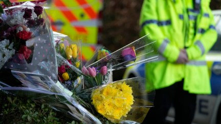 Floral tributes are left as police attend the scene where 16-year-old Brianna Ghey was found with multiple stab wounds on a path at Linear Park in Culcheth.