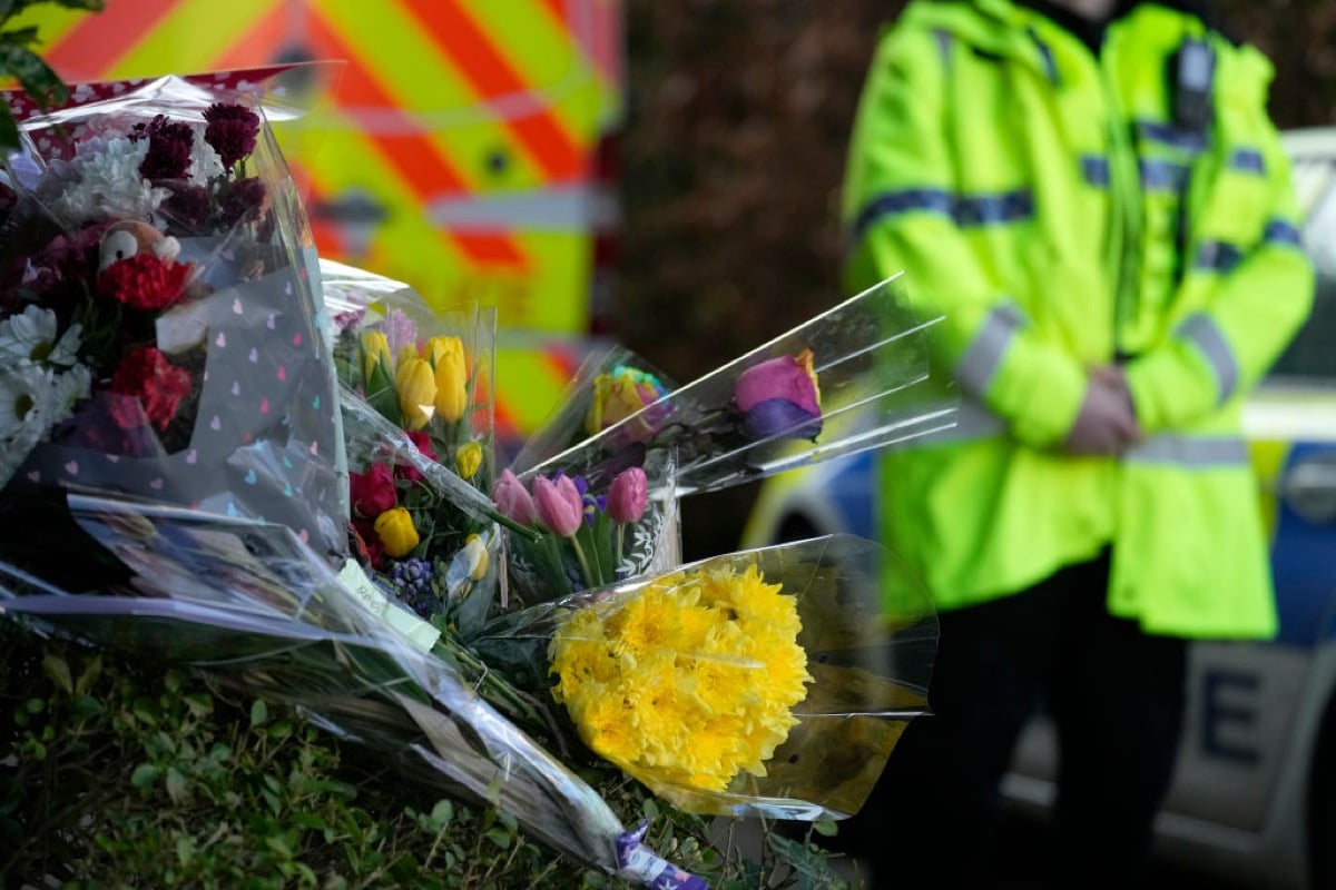 Floral tributes are left as police attend the scene where 16-year-old Brianna Ghey was found with multiple stab wounds on a path at Linear Park in Culcheth.