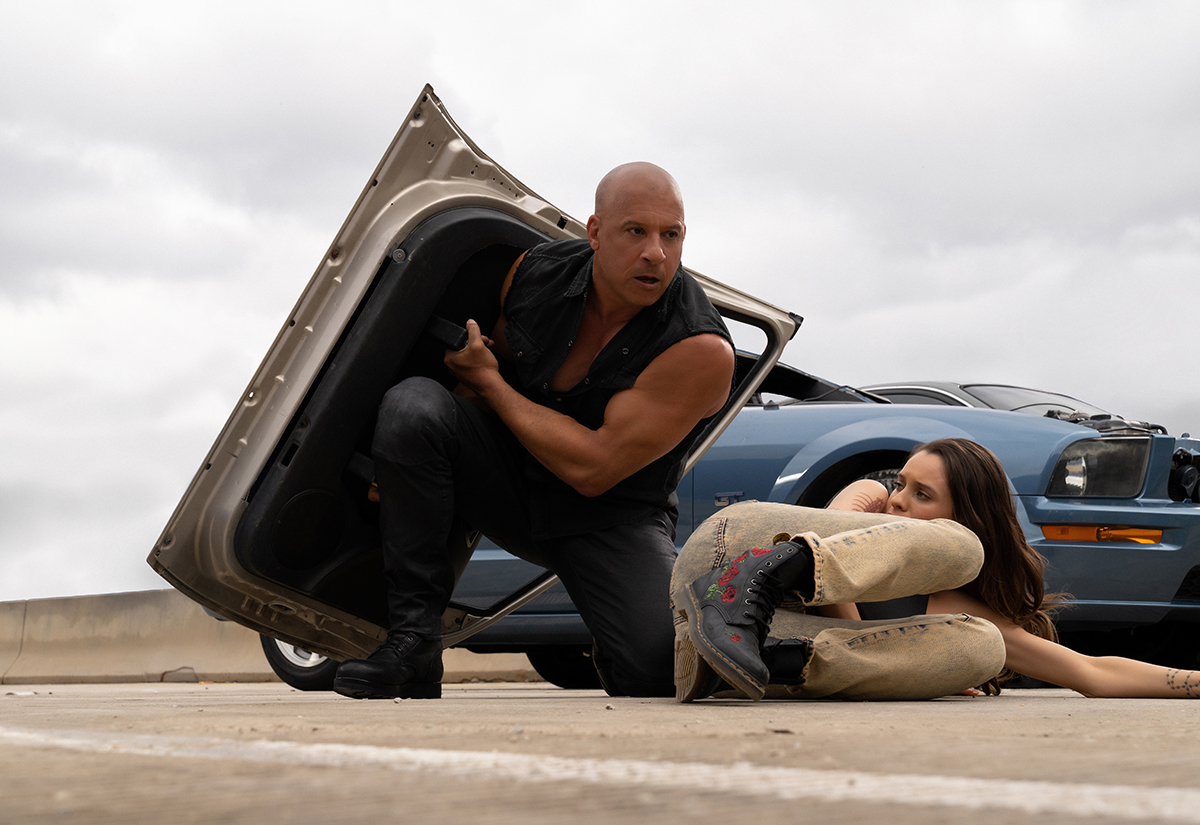 Dominic Toretto (Vin Diesel) using a car door as a shield in 'Fast X'