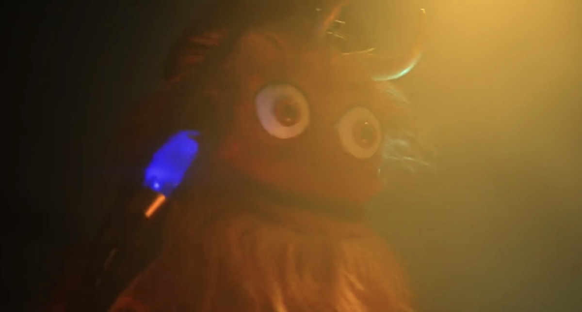 Gritty dressed in Loki horns and holding the scepter, in dramatic lighting.