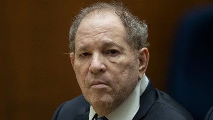Harvey Weinstein sits in court in a suit, looking directly into the camera.