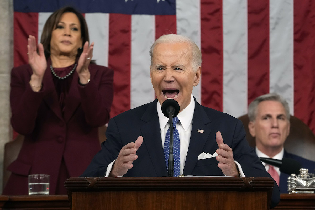 Joe Biden looks passionate while delivering his state of the union address. Behind him, Kamala Harris stands and applauds and Kevin McCarthy sits with a neutral expression