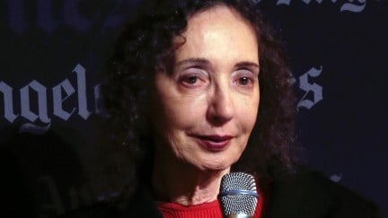 joyce carol oates holds a microphone. The Los Angeles Times logo is visible behind her.