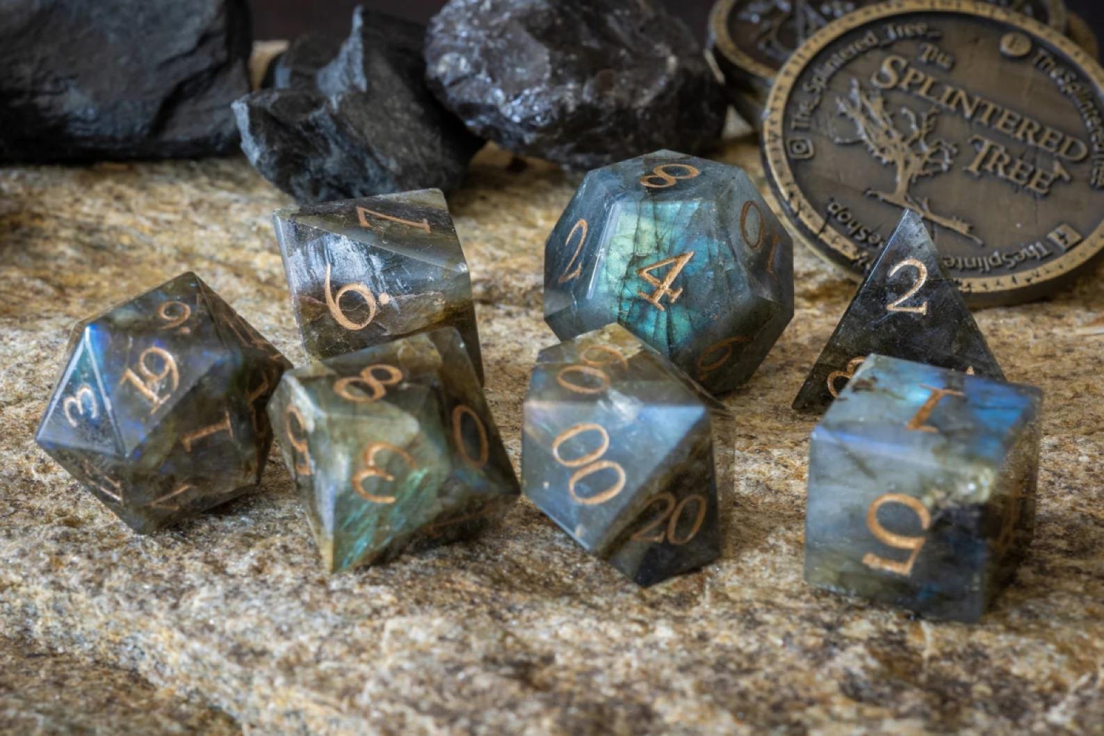 Dice carved from labradorite with gold numbers