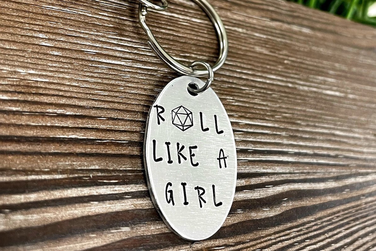 A handstamped keyring that says "roll like a girl"