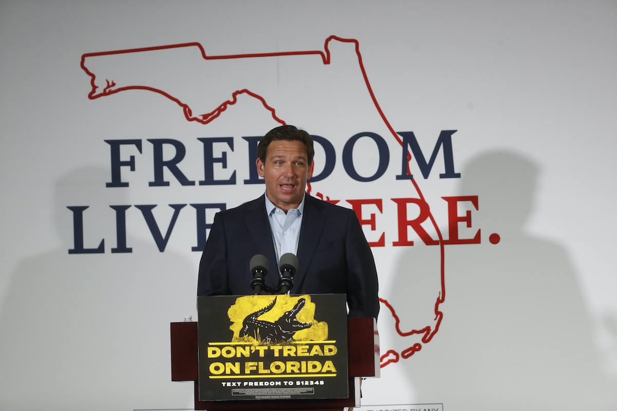 Ron DeSantis speaks from a podium with a banner behind him reading "freedom lives here"