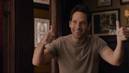 Scott Lang (Paul Rudd) stands in a living room wearing a T-shirt and giving two thumbs up.