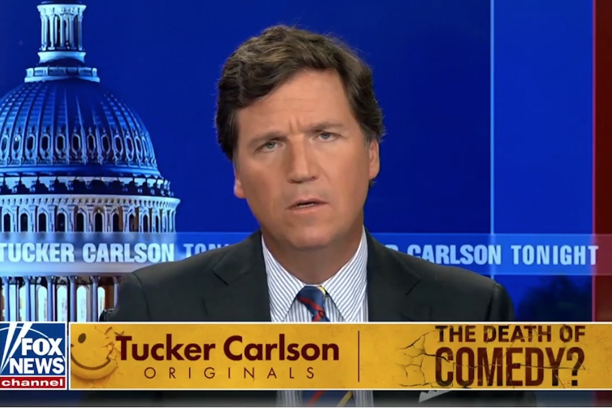 Tucker Carlson has a confused look on his face during a segment on his show above a chyron reading "the death of comedy"