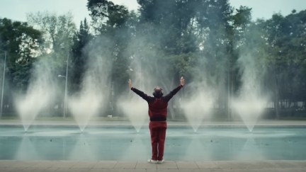 A man raises his arms by a large fountain in an ad for TurboTax.