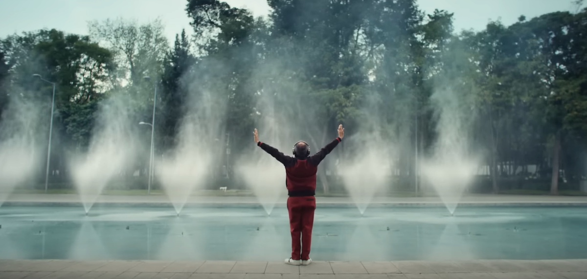 A man raises his arms by a large fountain in an ad for TurboTax.