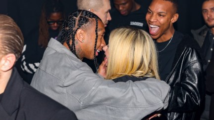 Tyga and Avril Lavigne smile while intimately close to each other's faces, attending the Mugler x Hunter Schafer party as part of Paris Fashion Week