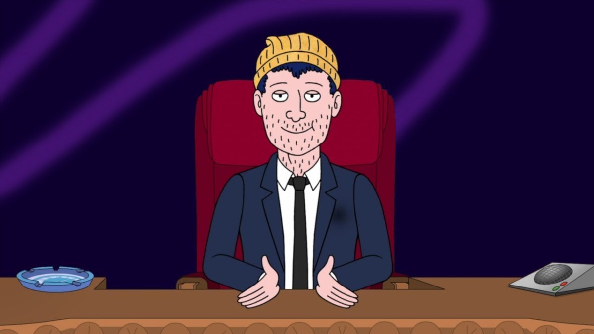 Todd Chavez wears a suit while sitting in a high back chair